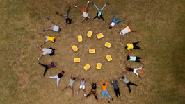As seen from above, Sunbox Ambassadors in South Africa positioned on a field replicating the Sunshine Cinema logo