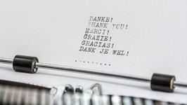 Paper in typewriter which includes the words Danke, Thank you, Merci, Grazie, Gracias, Dank je wel.