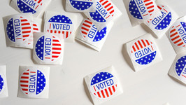 A photo of several "I Voted" stickers featuring a US flag design