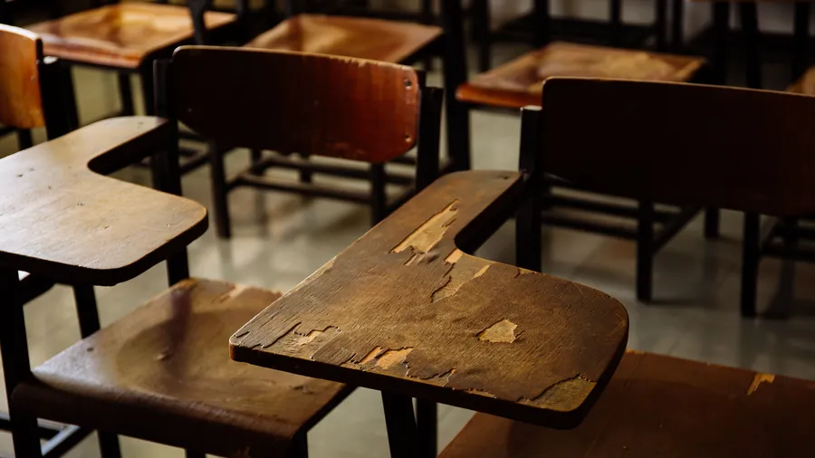 Empty classroom with wooden row lecture chairs in classroom.