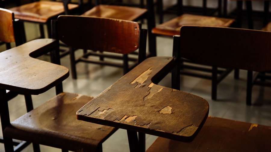 Empty classroom with wooden row lecture chairs in classroom.