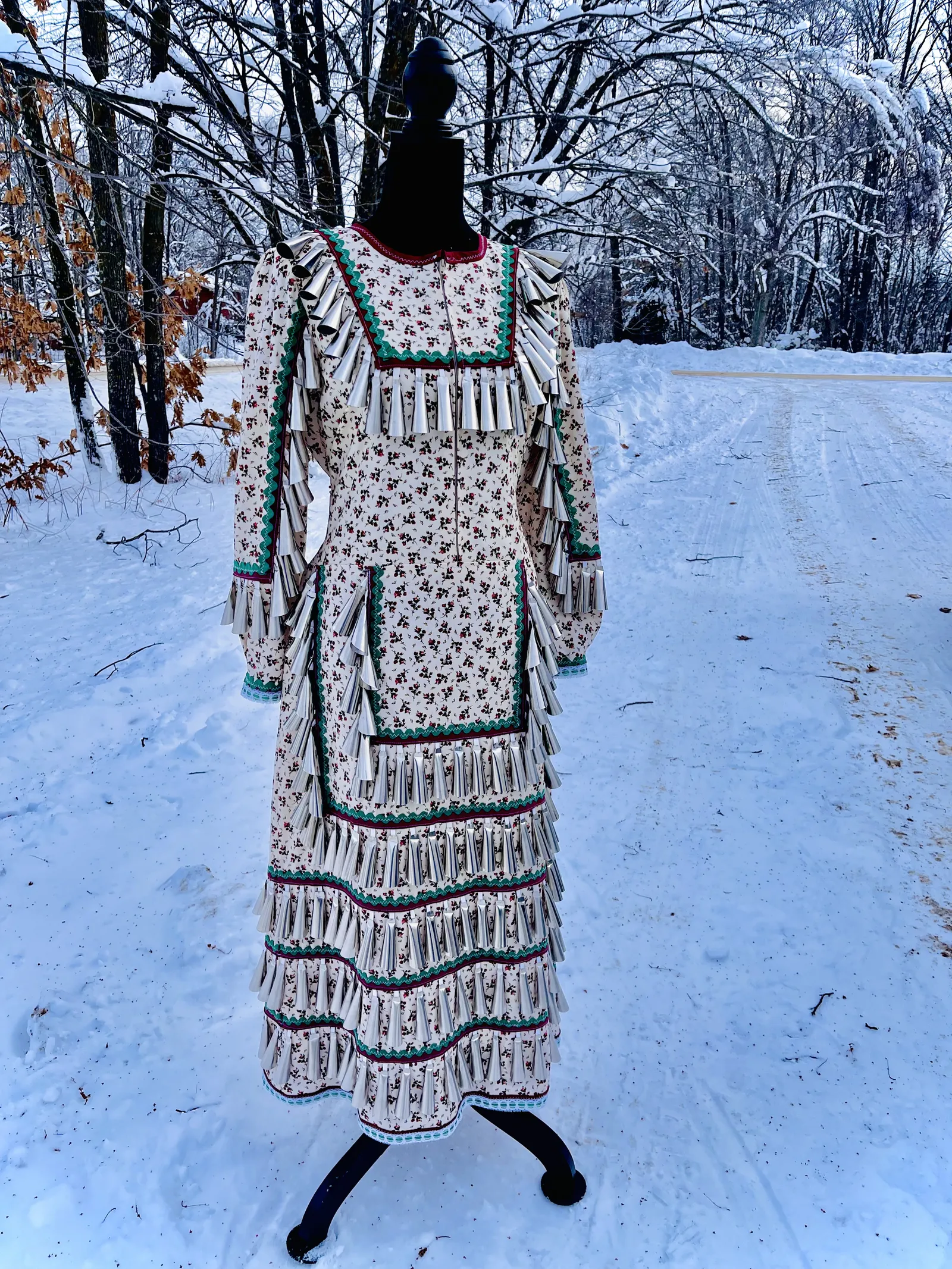 Long patterned dress displayed on a mannequin outdoors in a snowy landscape