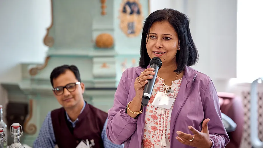 a woman with dark hair speaks into a microphone