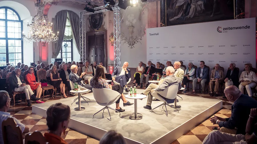a group of several people sitting in the middle of a larger crowd