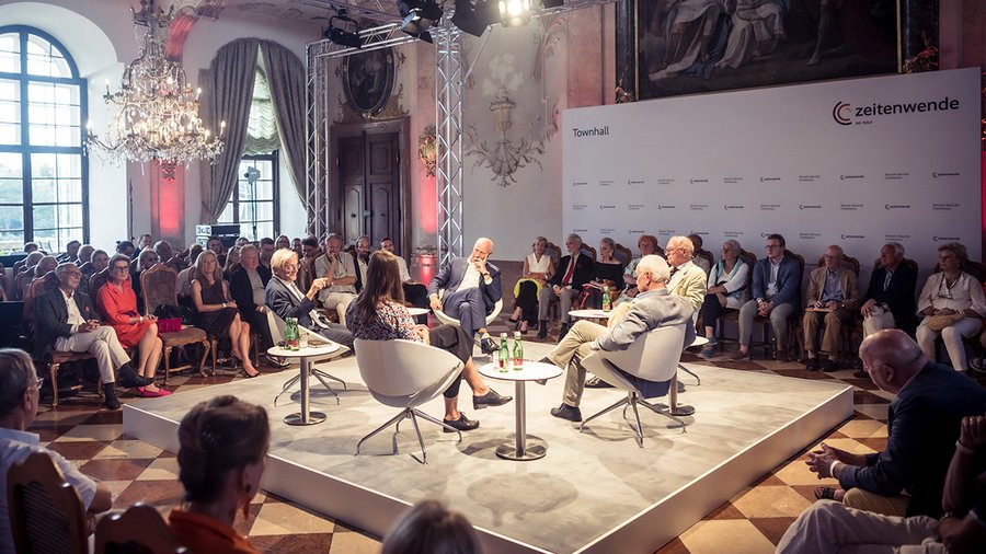 a group of several people sitting in the middle of a larger crowd