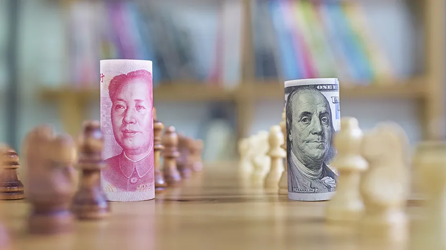 A Chinese Yuan bill and a US dollar bill on a chess board