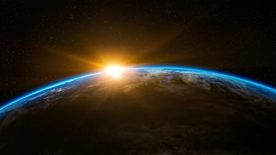 The sun rises on the earth's horizon.