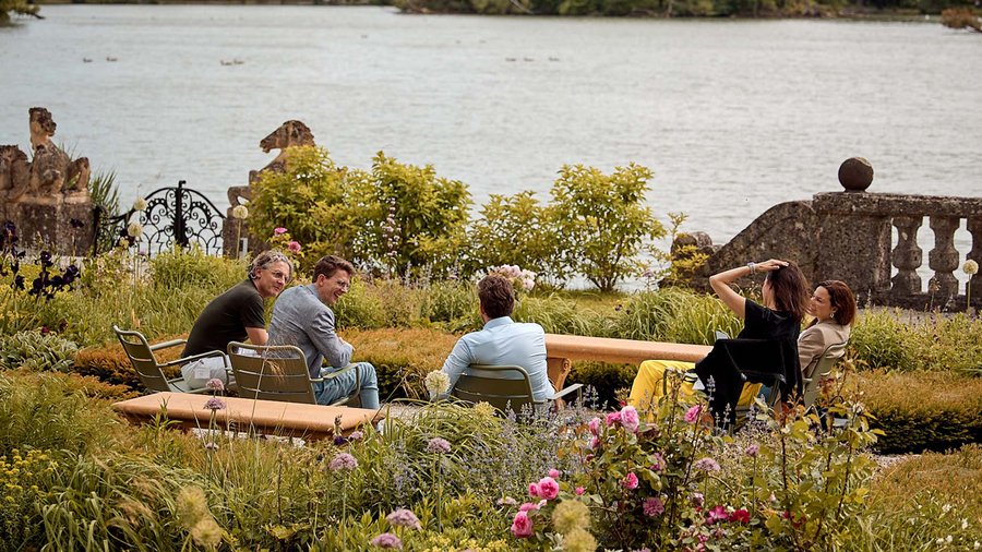 This photo shows five Sciana Fellows in conversation on the Mansbach Garden Parterre during the May 2024 residential meeting.
