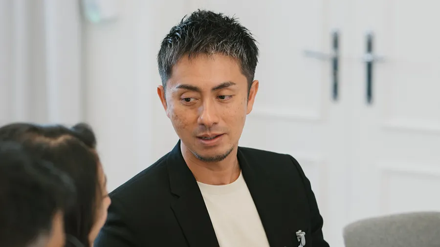 a man looks to the left while talking to a woman who is out of the frame