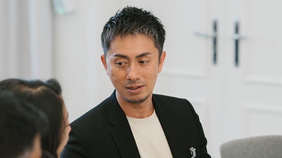 a man looks to the left while talking to a woman who is out of the frame