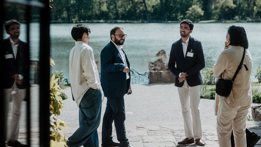 Four Salzburg Global Fellows, including Ashish Pandya, converse outside Schloss Leopoldskron during the Japan-India Transformative Technology Network in 2025.