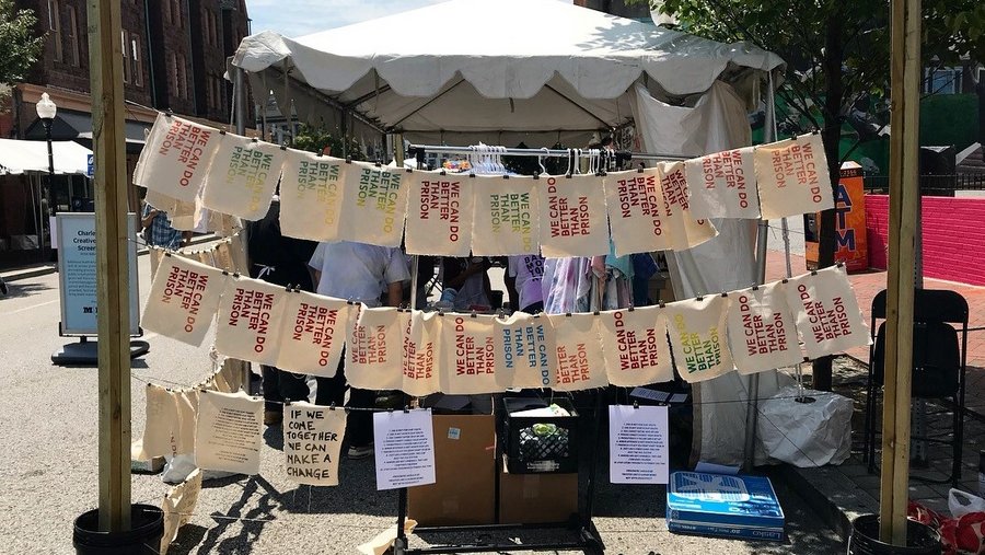 Signs hanging from clotheslines saying "we can do better than prison"