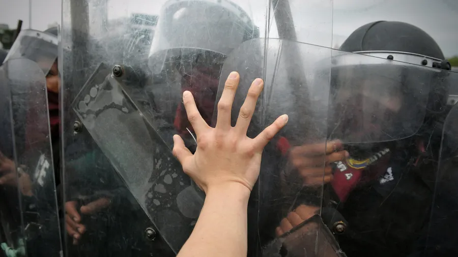 A protester from the nationalist Pitak Siam group pushes the shield of riot police during a violent anti-government rally with riot police on Nov 24, 2012 in Bangkok, Thailand.