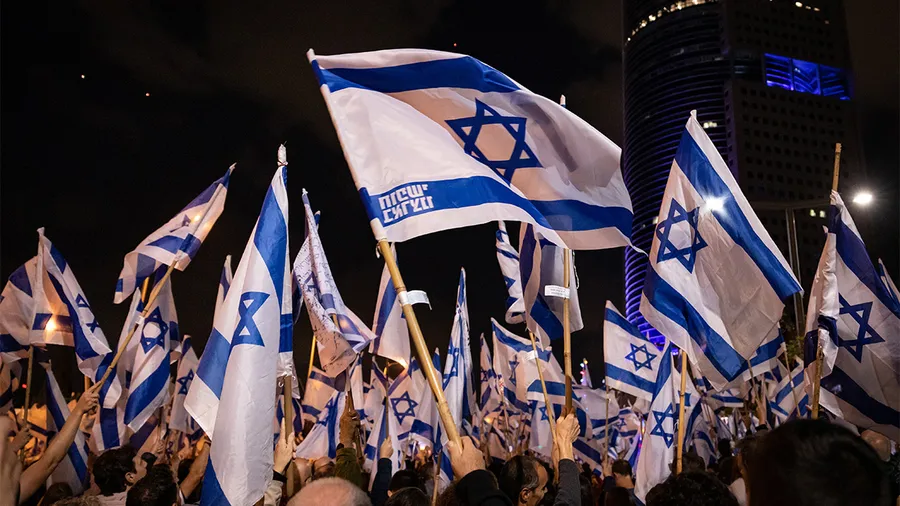 crowd of people waving flags of israel