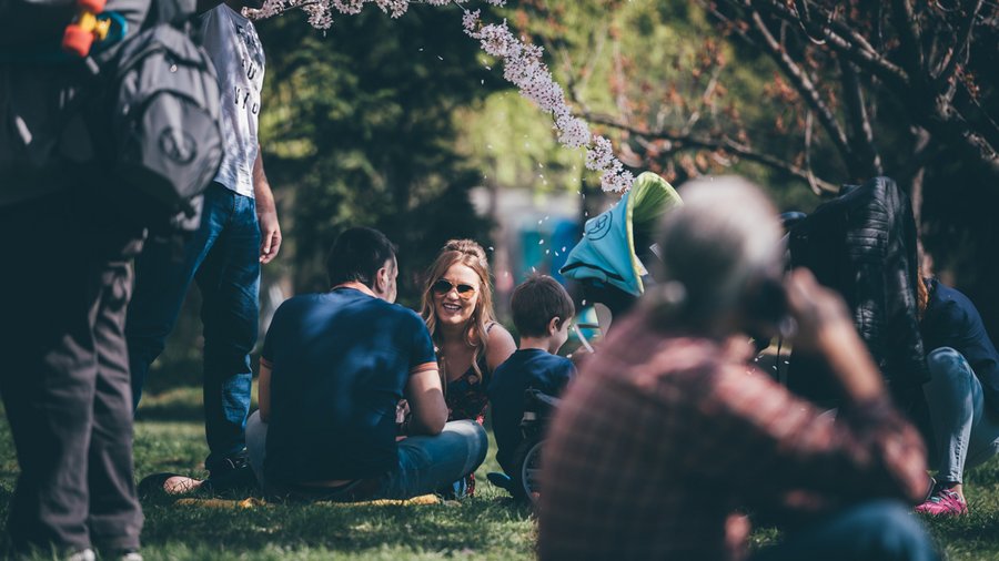 Man and woman sitting on grass in Herăstrău Park, Bucharest, Romania