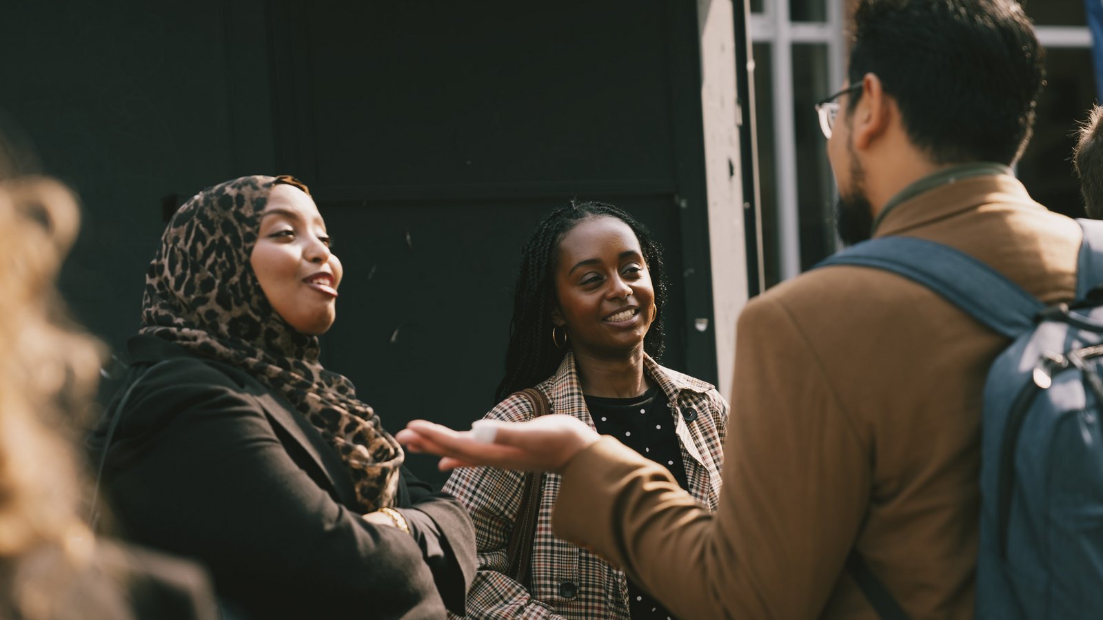a group of three individuals engage in a conversation