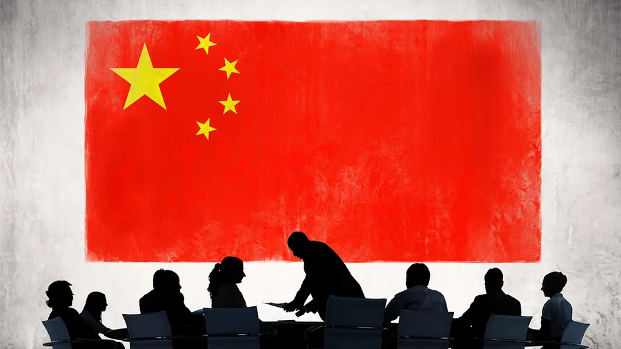 a group of figures sitting around a business table, with a chinese flag in the background