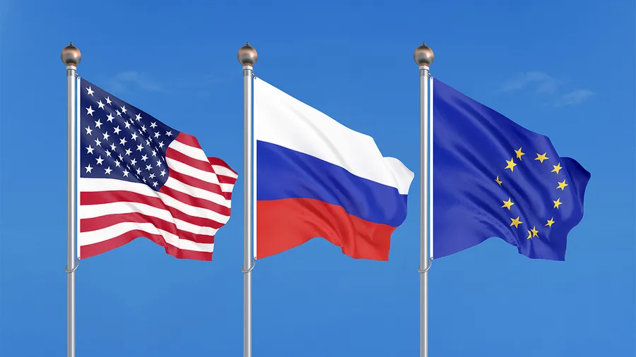 Flags of US, Russia, and EU flying in the wind against the blue background