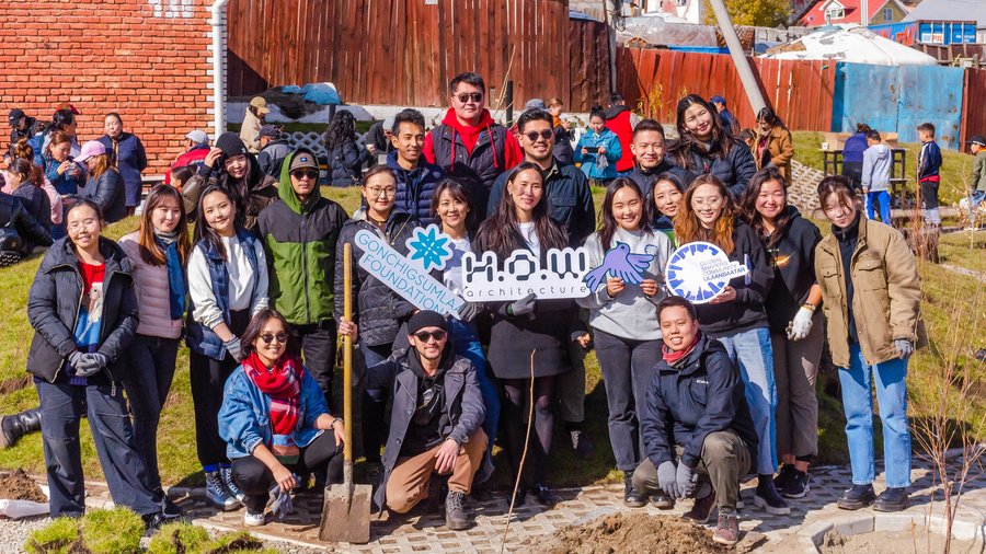 A photo of a group of people that includes Temuulen Enkhbat and others outside in a green space with the Ulaanbaatar Oasis project