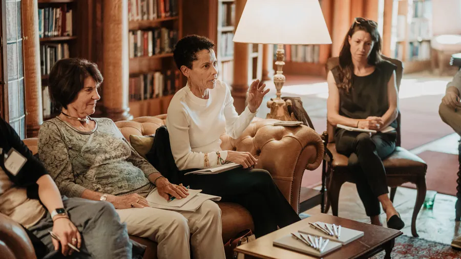 A few women sit in the Max Reinhardt Library during a conversation.