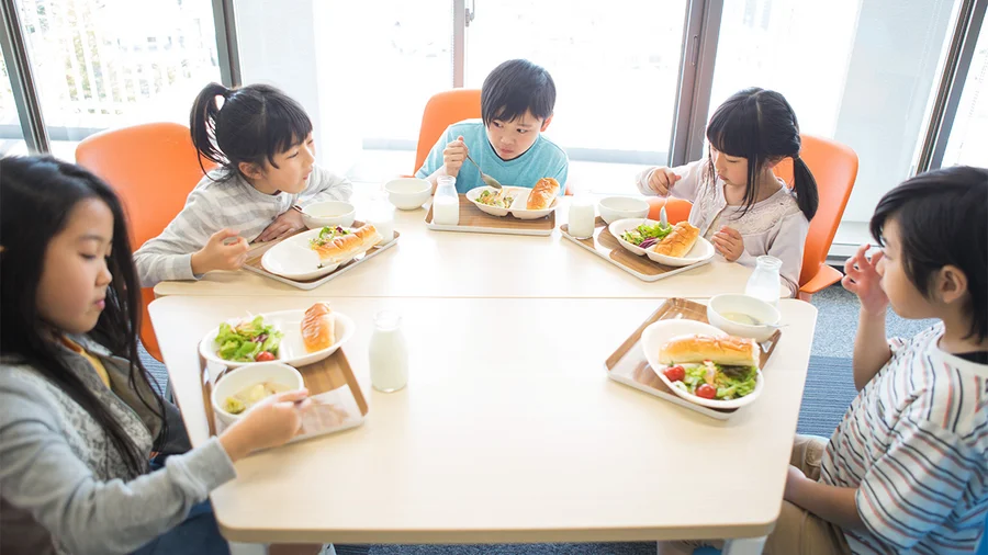 a group of young children eating a meal together