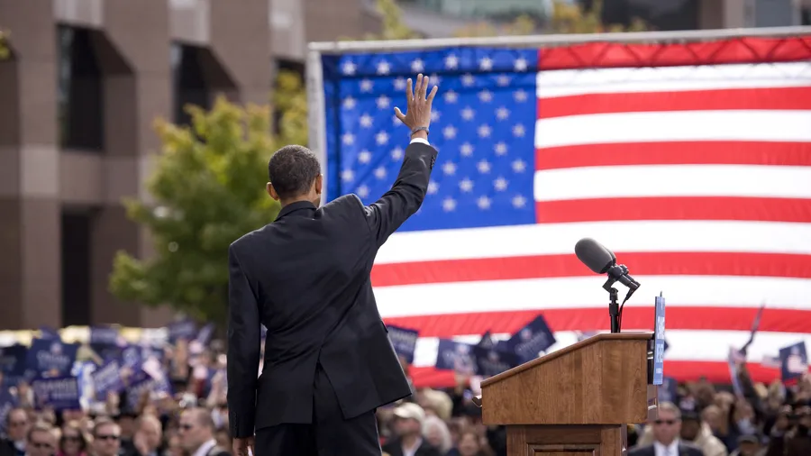 Presidential Candidate Barack Obama waves to crowd as he is framed against American Flag at early vote for change Presidential rally October 29, 2008 at Halifax Mall, Government Complex in Raleigh, NC