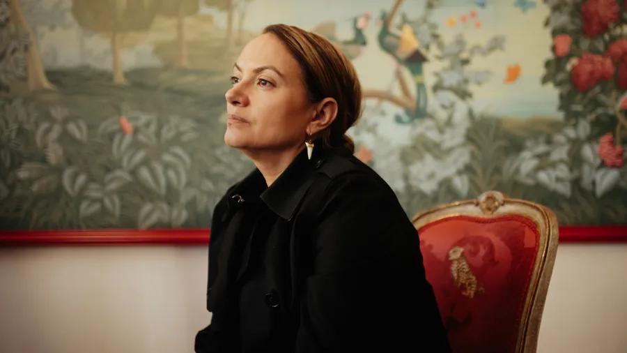 a woman sits in the Red Salon of Schloss Leopoldskron and looks to the left