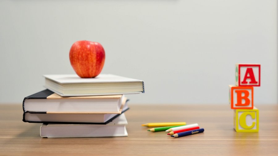 An apple with books and other learning materials
