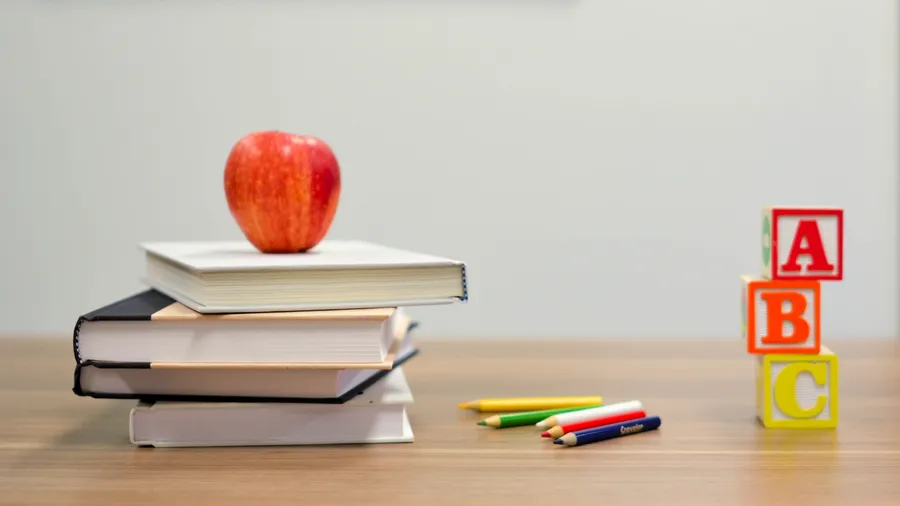 An apple with books and other learning materials