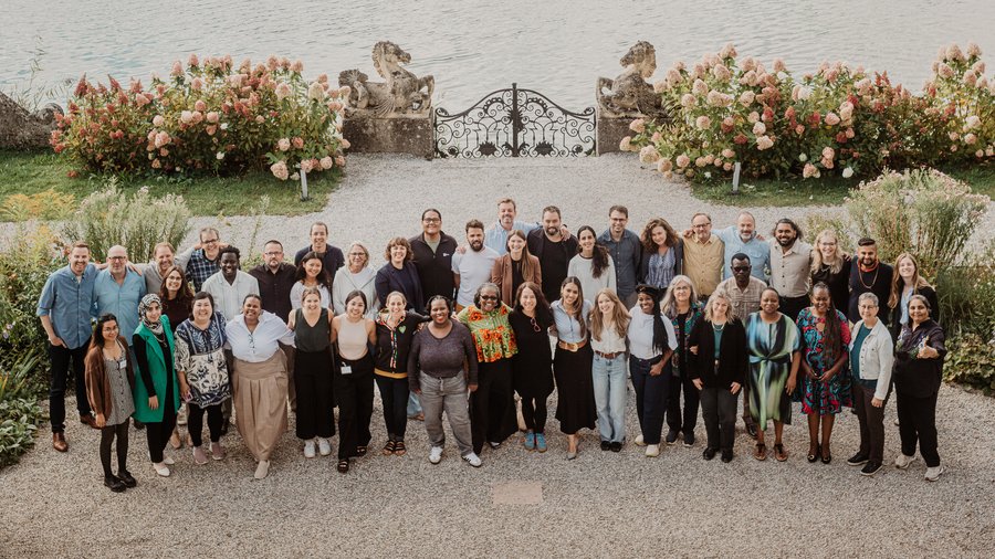 A group of Salzburg Global Fellows stand on the Mansbach Garden Parterre of Schloss Leopoldskron