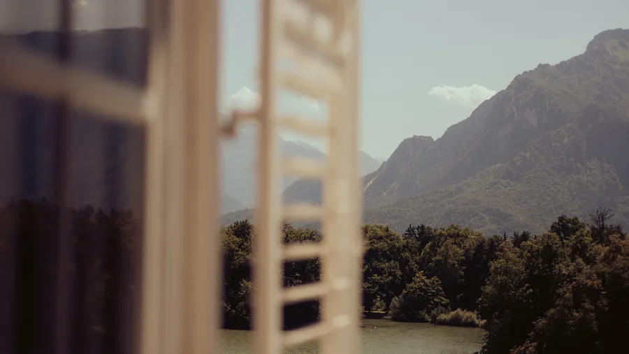 mountain view out of a window with window shutters blurred in view