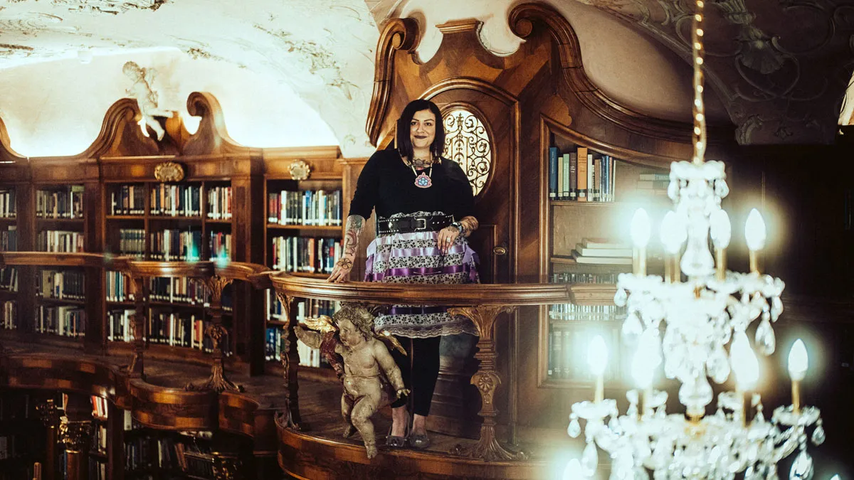 Woman in the Library With a Chandelier in the Foreground