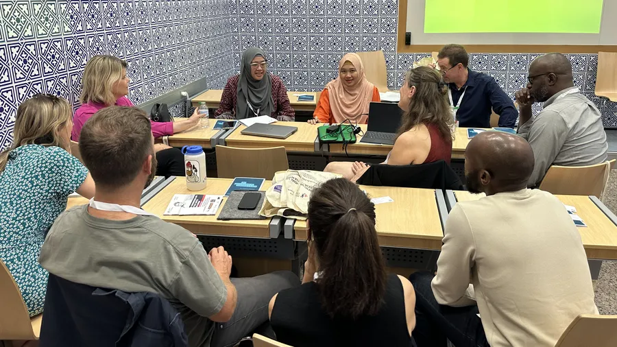 Woman speaks to group of people around a table