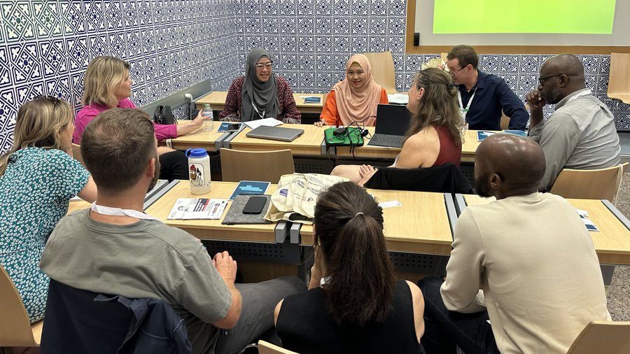 Woman speaks to group of people around a table