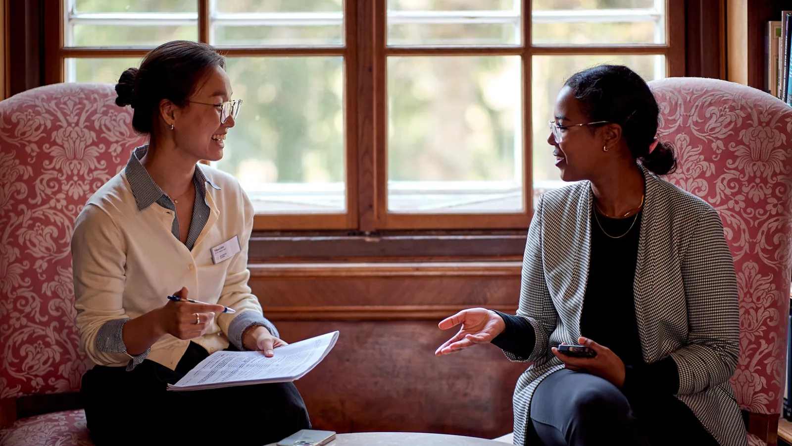 Two females talk beside window inside the Schloss Leopldskron