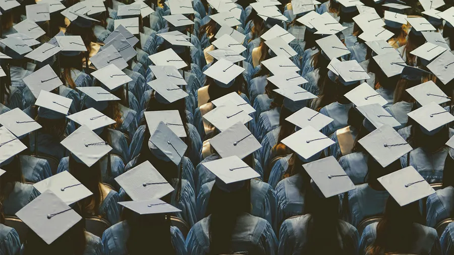 an audience of graduates wearing caps and gowns