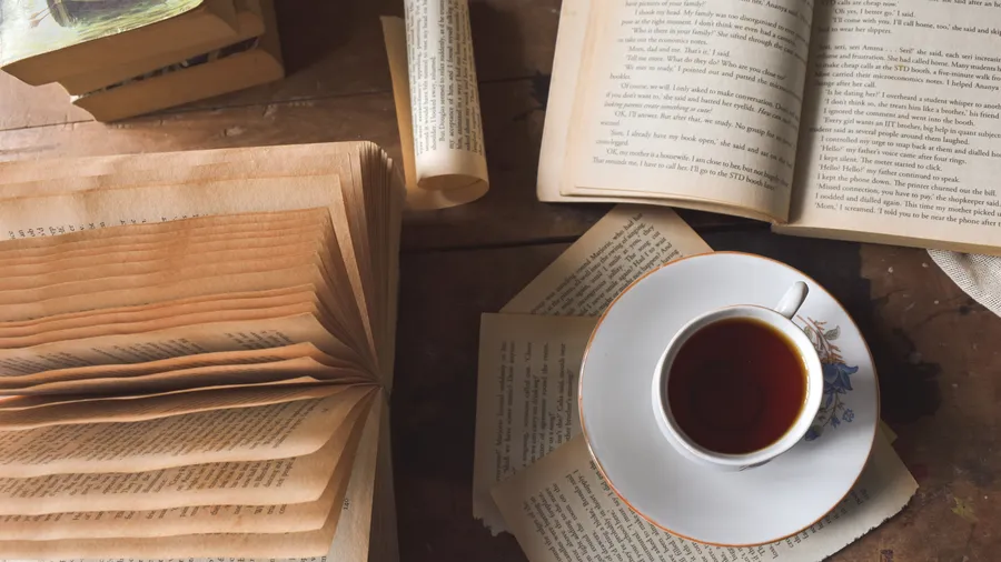 A cup of black tea with few books on a tabletop in Kerala, India
