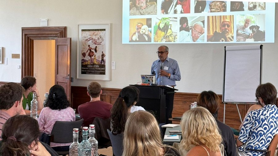 Sanjeev Chatterjee stands at the front of the Gallery in Schloss Leopoldskron while delivering a lecture to an audience of young people