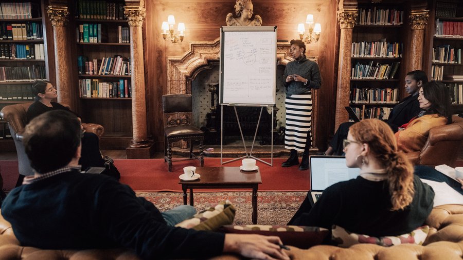 A group of Fellows holds a discussion in the Max Reinhardt Library of Schloss Leopoldskron