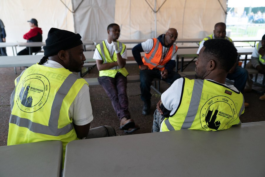 Men wearing yellow vests sitting together