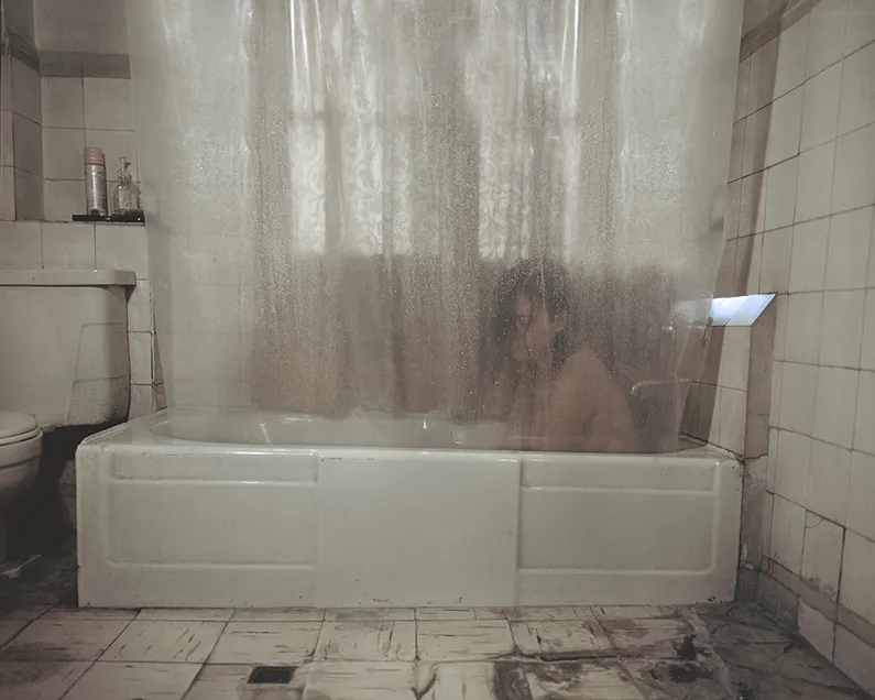 Woman in a Bathtub Behind a Shower Curtain
