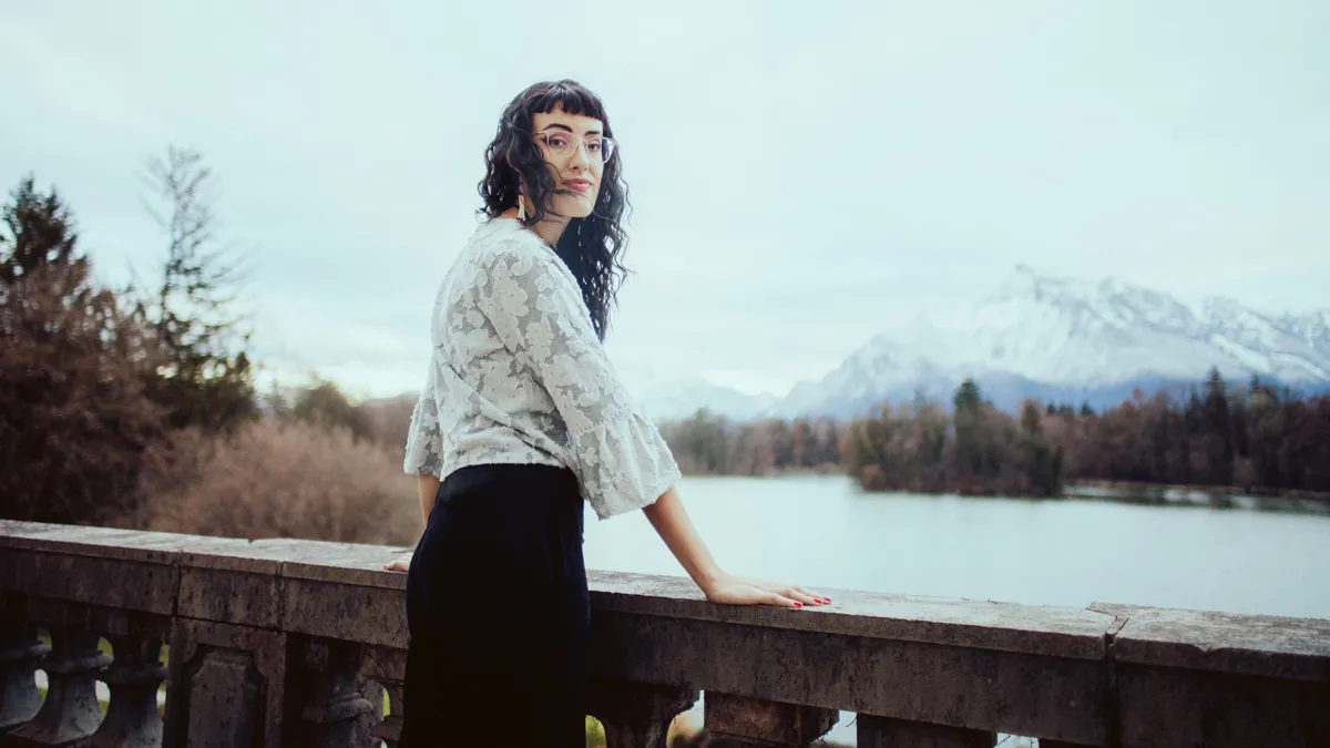 Person Outside the Castle, Looking Over Her Right Shoulder at the Camera, With the Untersberg and the Lake in the Background