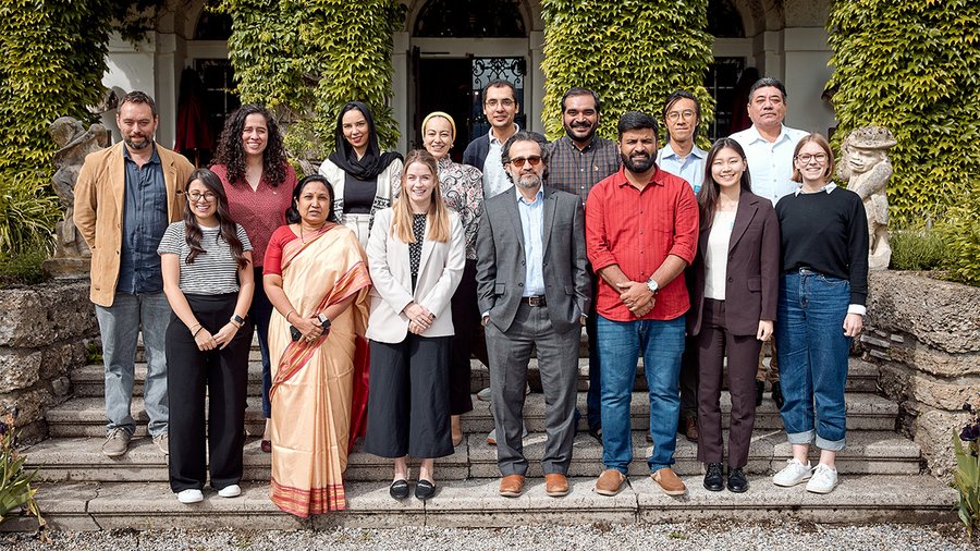 A group of people stands on steps smiling at the camera