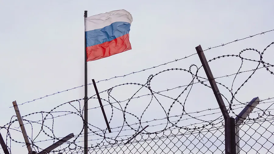 russian flag behind barbed wire