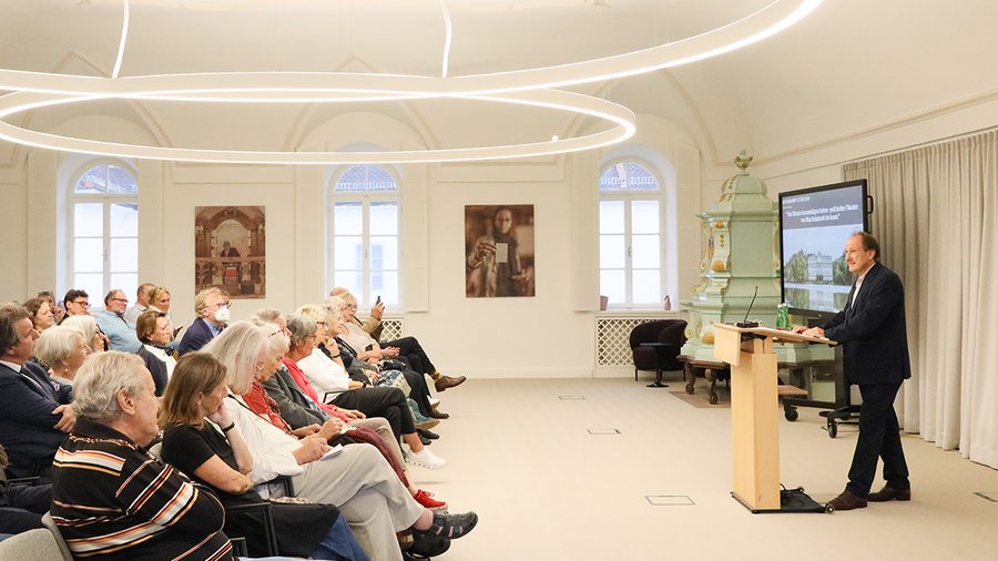 Markus Kupferblum stands at a podium delivering the 2024 Max Reinhardt Lecture in front of an audience in Fellows Hall.