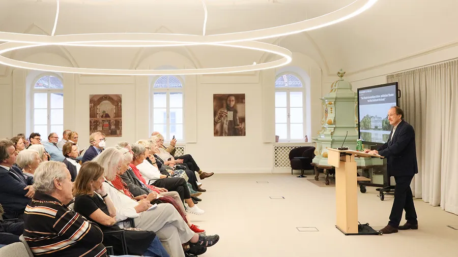 Markus Kupferblum stands at a podium delivering the 2024 Max Reinhardt Lecture in front of an audience in Fellows Hall.