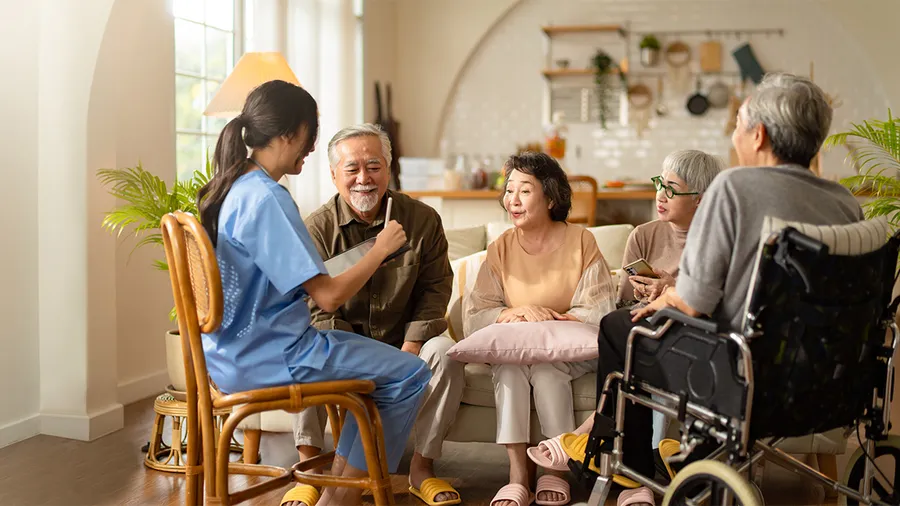 a photo of a young nurse surrounded by happy elderly patients