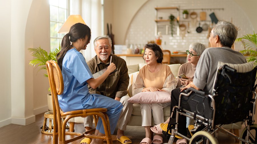 a photo of a young nurse surrounded by happy elderly patients