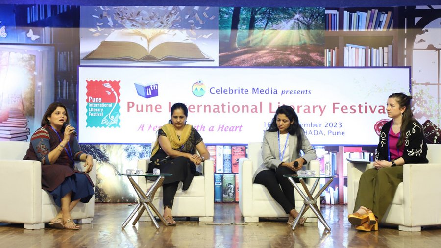 four women sit on a stage for a panel discussion