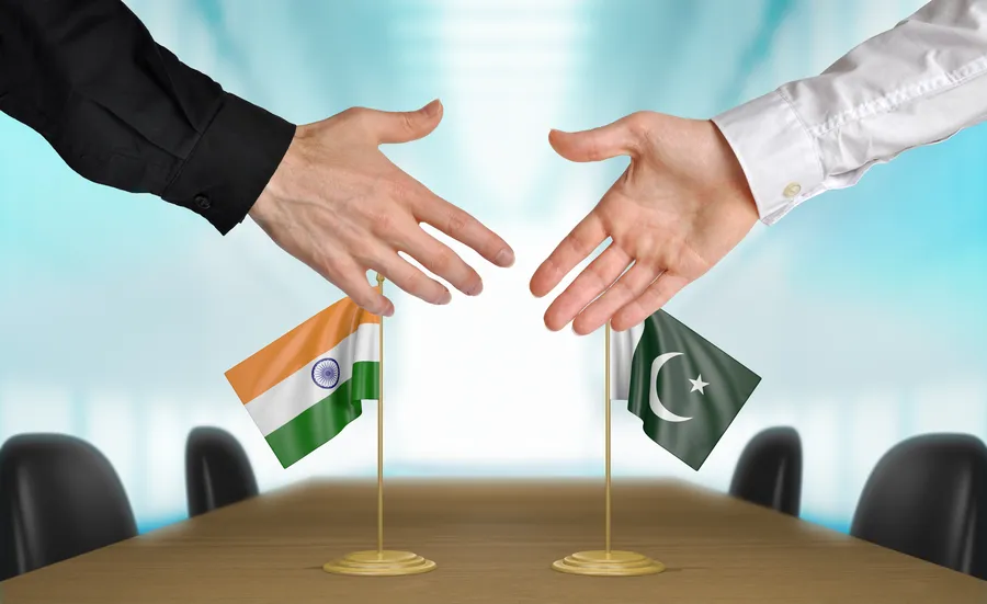 India and Pakistan diplomats shaking hands to agree deal. Photo by David Carillet from Shutterstock.